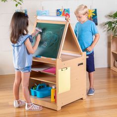 The transformative Desk to Easel Art Cart by Guidecraft is the perfect art space for your budding artist. Easily switch from a flat art desk to an angled drawing station with durable hinges that lock into place. The double-sided easel can be set up as a chalkboard, a write-on/wipe-off board, or used with the included paper roll, allowing multiple artists to work at the same time. Complete with a variety of storage compartments and included fabric bins, this unique art furniture provides the perf Kids Art Easel, Table Activities For Toddlers, Art Cart, Activity Center, Art Easel, Fabric Storage Bins, Kids' Desk, Kid Desk, Painted Cups