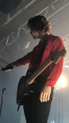 a man playing guitar on stage at a concert