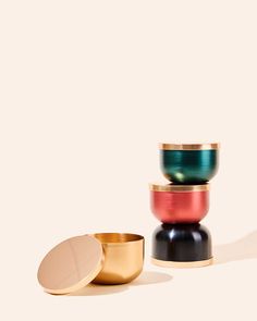 three bowls stacked on top of each other with lids in different colors and shapes,