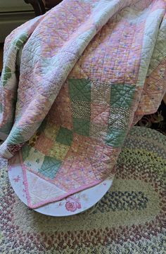 a pink and green quilt on top of a white plate