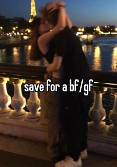 a man and woman kissing in front of the eiffel tower