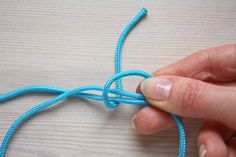 someone is tying a blue string together