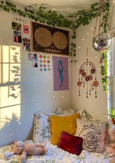 a bed with lots of pillows on top of it and some plants growing up the wall