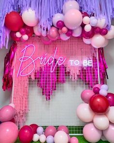 balloons and streamers decorate the entrance to a bridal party in pink, purple and white