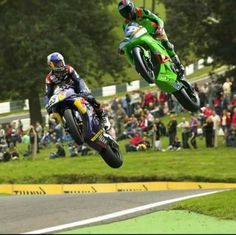 two motorcyclists in mid air during a race