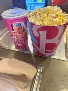 two buckets of popcorn sitting on top of a table