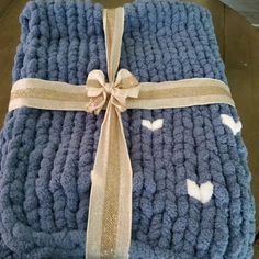 a blue blanket with white butterflies on it and a brown ribbon tied around the edge