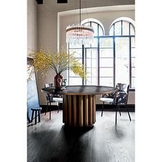 a dining room table with chairs and a chandelier hanging from it's ceiling