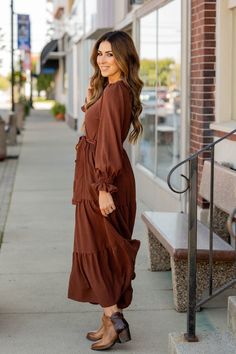 This stunning maxi dress is perfect for every event or occasion! The wrap top, slimming tie waist, fun flowy tiered bottom, and the balloon sleeves all come together seamlessly to create this classy dress! Whether you're going to work, a wedding, holiday party, church, or date night, we just know you will turn heads!100% PolyesterMachine wash cold on gentle cycle. Do not bleach. Tumble dry low. Iron low. Maxi Dress Family Photos Fall, Semi Casual Fall Wedding Attire Guest, Shoes To Wear With Maxi Dress, Winter Church Dresses, Boho Maxi Dress Outfit, Simple Church Outfits, Closet Revamp, Dresses With Cowboy Boots, Fall Fashion Dresses