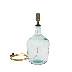 an empty glass bottle with a gold colored cord attached to the end and a light bulb on top