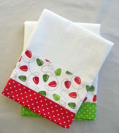 three pieces of white fabric with red, green and white polka dot designs on them