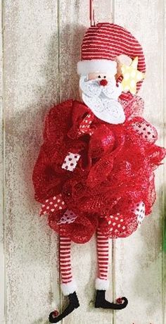 a red and white christmas decoration with santa clause on it's head hanging from the wall