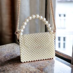 Explore our exquisite collection of handmade bags, featuring unique designs perfect for any occasion. Elevate your style with our elegant Women's Bag, ideal for weddings and special events. Our White Pearl Handbag is a luxurious accessory that adds a touch of sophistication to your ensemble. Whether you're a bride looking for the perfect bag or searching for a Valentine's Day gift, our range of trendy and carefully crafted bags ensures you stand out at any evening party. Embrace the allure of ou Cream Rectangular Box Bag For Gifts, Rectangular Cream Box Bag For Gift, Rectangular Cream Box Bag For Gifts, Pearl Handle Tote Bag For Gift, Gift Tote Bag With Pearl Handle, Party Cream Top Handle Bag, Cream Top Handle Party Bag, Cream Top Handle Party Bags, Cream Top Handle Bag For Party