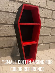 a red and black book shelf next to a brick wall with the words small coffin picture used for color reference