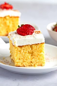 a piece of cake with whipped cream and strawberries on top sits on a plate