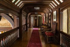 the hallway is lined with wooden paneling and red carpet