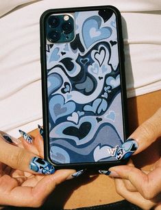 a woman holding up her phone case with blue and white designs on the back cover