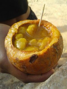 a person holding a pastry filled with fruit