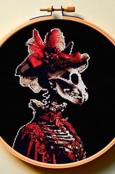 a cross stitch picture of a woman in a red dress with a hat on her head