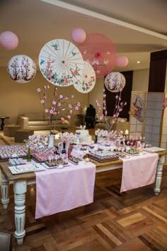 the table is set up with pink and white decorations