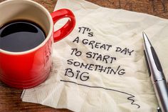 a cup of coffee sitting on top of a napkin with the words it's a great day to start something big