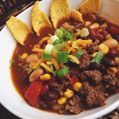 a white bowl filled with chili and tortilla chips