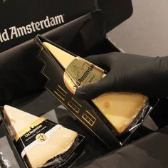 a person in black gloves is holding some cheese