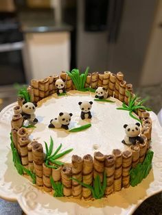 a cake decorated with bamboo sticks and panda bears