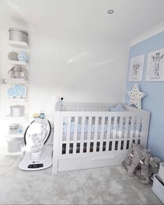 a baby's room with blue walls and white furniture