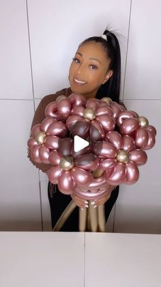 a woman holding a bunch of balloons in front of her face