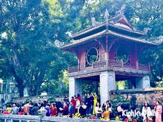 a group of people standing in front of a pagoda