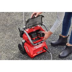 a woman is cleaning the floor with a power washer on top of her feet