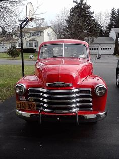 an old red car is parked in the driveway