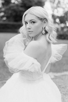 a woman in a white dress posing for a photo