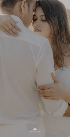 a man and woman embracing each other in front of the camera with their eyes closed