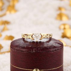 a heart shaped diamond ring sitting on top of a wooden box with white furnishing