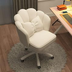 a white chair with a bow on it sitting in front of a desk and computer