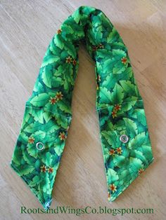 a green flowered tie laying on top of a wooden floor