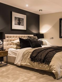 a bedroom with a bed, nightstands and pictures on the wall