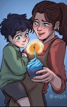 a woman holding a cupcake with a candle in it and a boy next to her