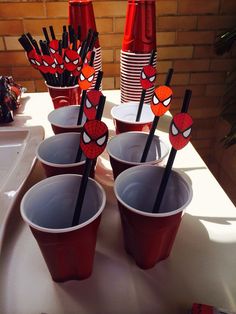 spiderman themed cups and straws on a table