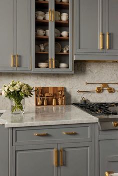 a kitchen with gray cabinets and gold pulls on the cupboards is pictured in this image