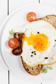 an egg is on top of toast with tomatoes