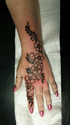 a woman's hand with flowers and vines on the left side of her arm