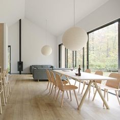 a dining room table and chairs in front of large windows with wood flooring on both sides