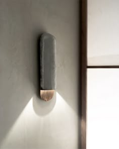 an object is mounted on the wall with a light coming from it's side