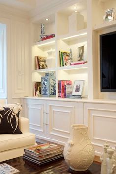 a living room filled with furniture and a flat screen tv mounted on a wall above a fireplace