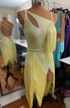 a mannequin wearing a yellow fringed dress