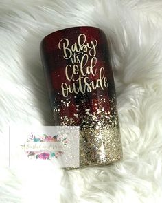 a red and gold flask with glitter on the bottom that says baby it's cold outside