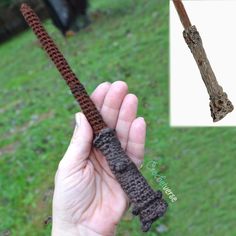 a hand holding a piece of crocheted material in front of a grass field